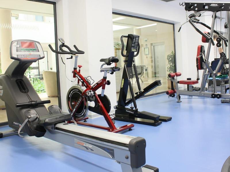 Nowoczesny sprzęt fitness w jasnej sali z dużym oknem.