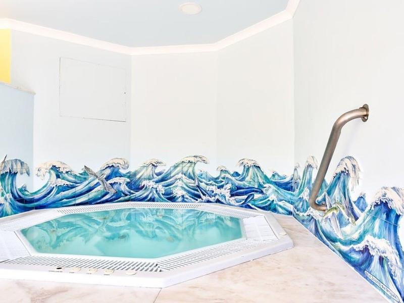 Nowoczesne jacuzzi wewnętrzne z dekoracyjnym wzorem fal na krawędzi.