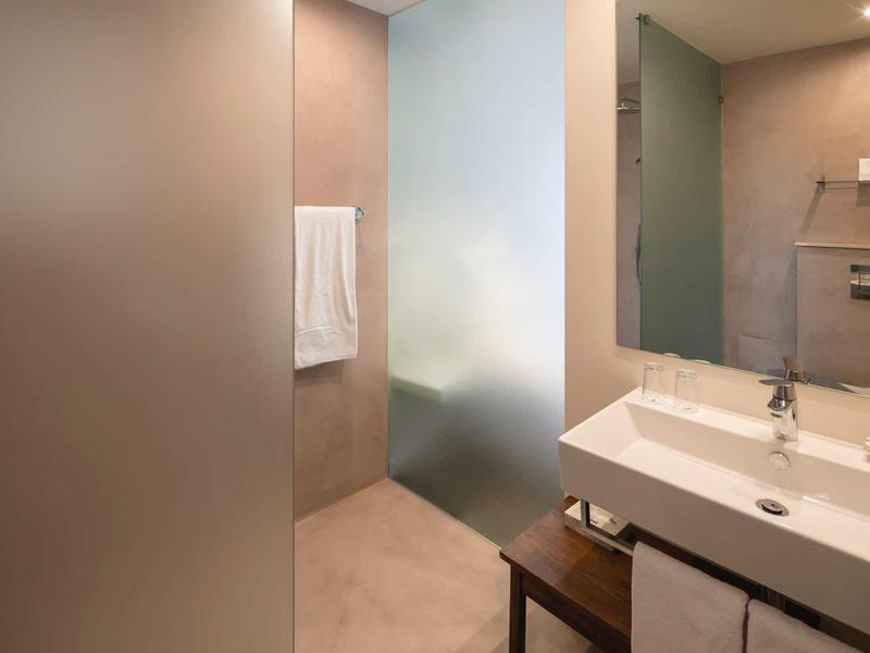 Moderne badkamer met wastafel, spiegel en matglas wand.