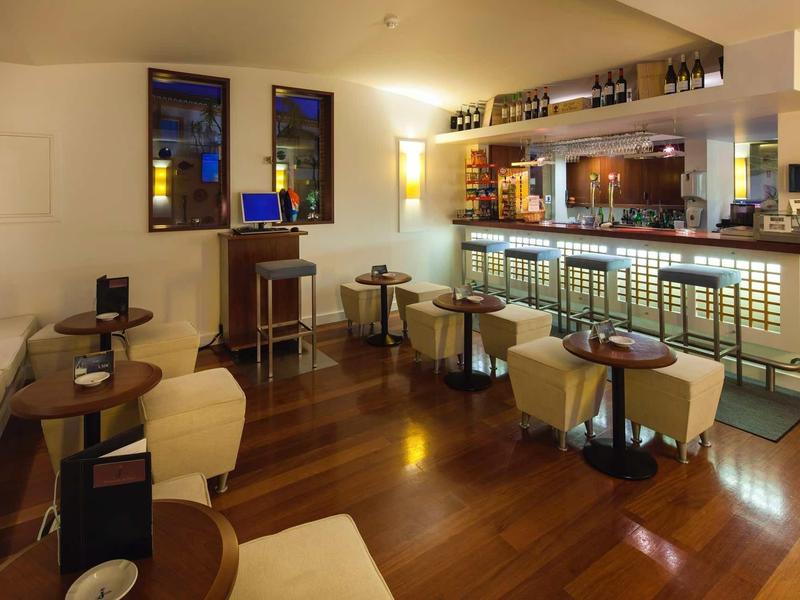 Gezellige hotelbar met houten vloer, zitgedeeltes en verlichte moderne bar.