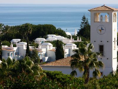Witgeschilderde gebouwen en een klokkentoren bij de zee