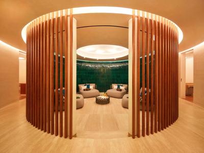 Moderne ronde ontspanningsruimte met houten lamellen en gezellige zithoek.