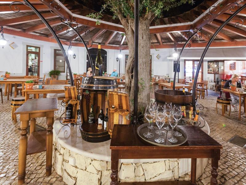 Gezellig buitenrestaurant met houten meubels en lantaarns onder de open lucht