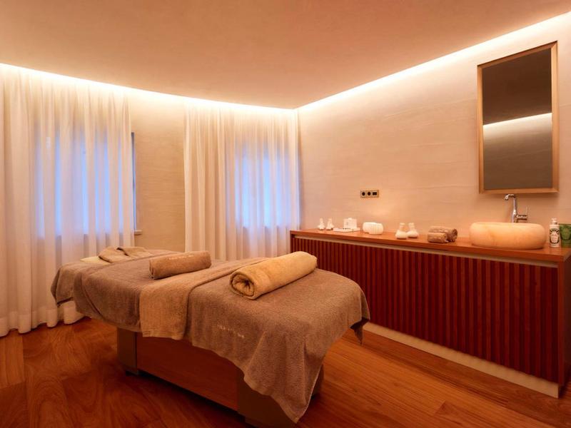 Gezellige wellnessruimte met twee massagetafels, warm licht en rustige sfeer.