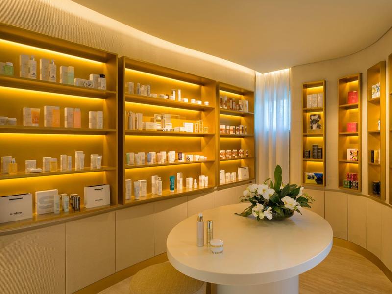 Elegant verlichte wellnesswinkel met spa-producten en ronde tafel met bloemstuk.