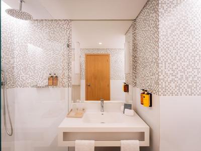Modernes Badezimmer mit Dusche, Waschbecken und Toilette in neutralen Farben.