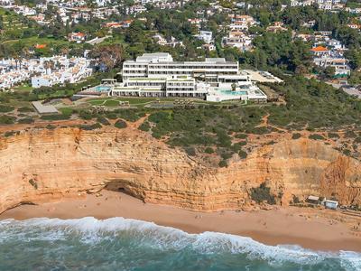 Hotel an einer Klippe mit Blick auf einen Strand und das Meer in einer Küstenstadt.