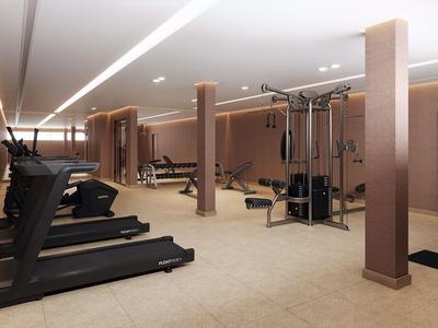 Moderne Hotel-Fitnessstudio mit Laufbändern und Krafttrainingsgeräten in hellem Raum.
