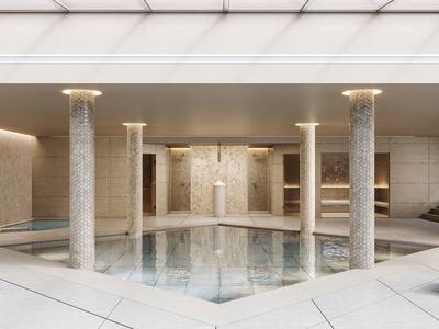 Moderner Innenpool mit Marmorstützen und Duschbereich in einem Hotel.