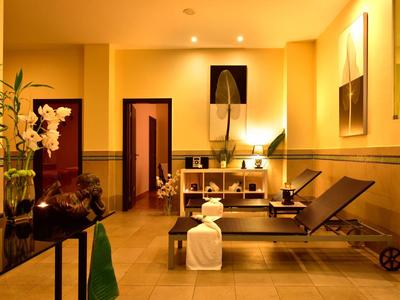 Area benessere calda e accogliente con lettini da massaggio e illuminazione d'atmosfera.