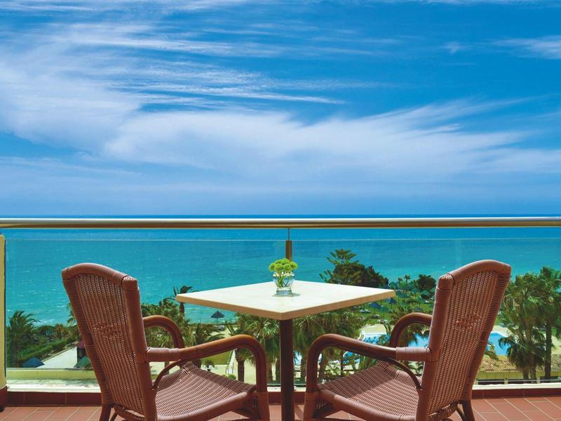 Balcone con tavolo e sedie con vista sul mare e sul cielo azzurro