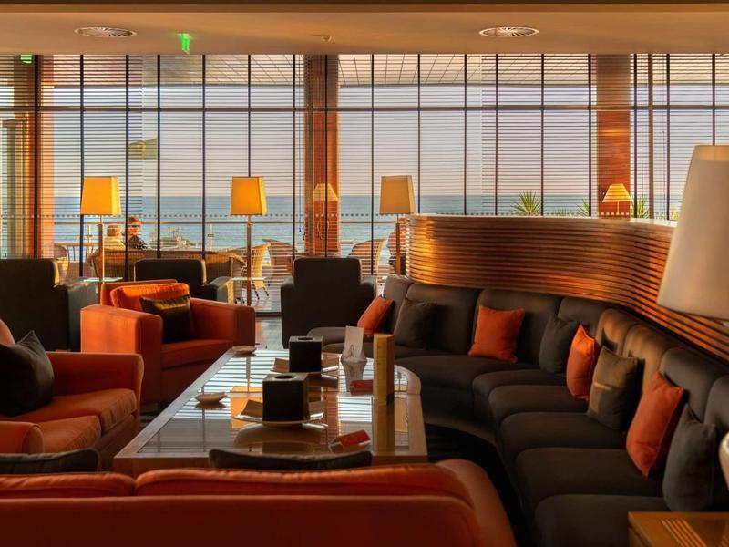 Mobilier de salon confortable avec lumière chaude et grande fenêtre pour la détente à l'hôtel.