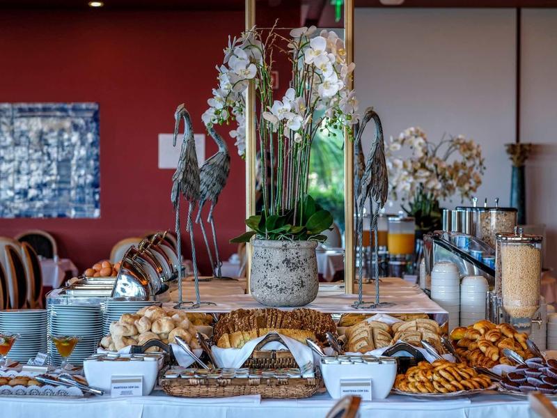 Buffet avec diverses pâtisseries, biscuits et céréales en bocaux dans un restaurant.