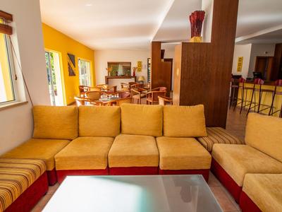 Gemütliche Hotel-Lounge mit gelben Sesseln und Blick auf den Essbereich