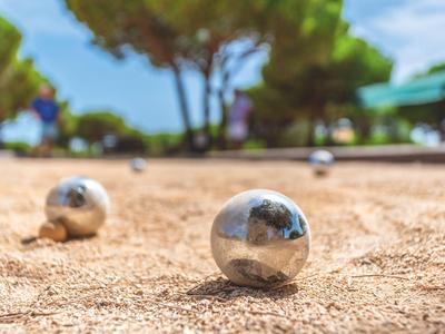 Silver balls on sandy ground, outdoor game in bright sunshine