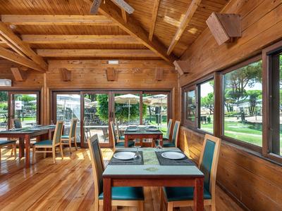 Accogliente ristorante con tetto in legno, grandi finestre e vista sull'area verde esterna
