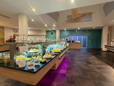 Großer, moderner Buffetbereich mit reich gedeckten Speisetischen in einem Hotel.