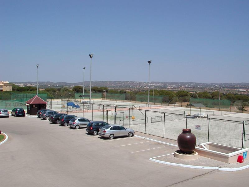 Parcheggio aperto accanto ai campi da tennis con vista su un ampio paesaggio.