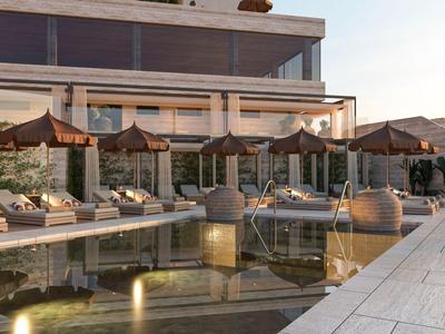 Moderner Hotelpoolbereich mit Liegestühlen und Sonnenschirmen am Abend.