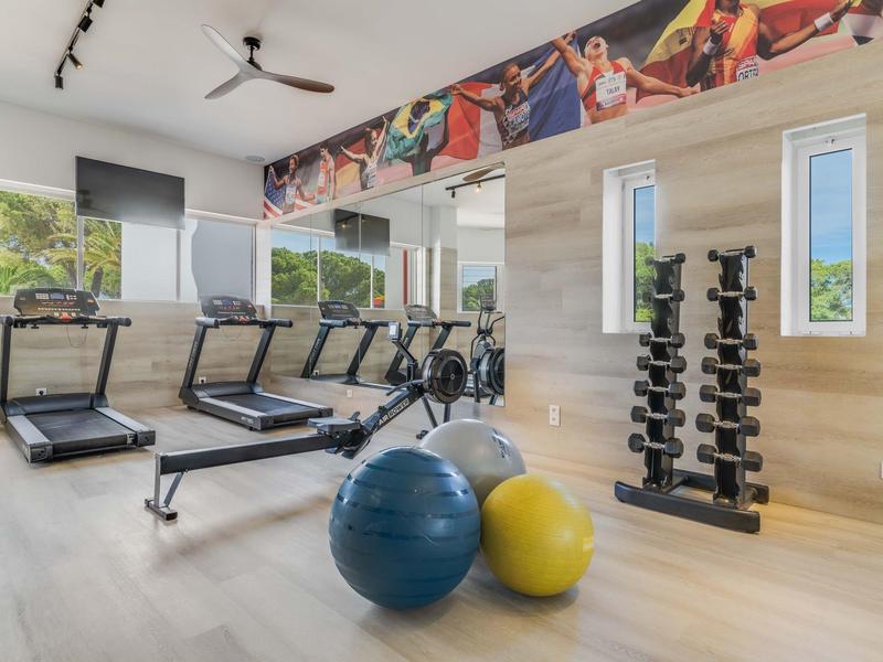 Palestra luminosa con tapis roulant, manubri e palle da ginnastica con vista esterna.