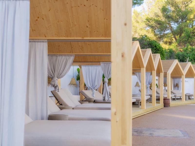 Diverse lettini coperti di lusso con tende bianche all'aperto alla luce del giorno