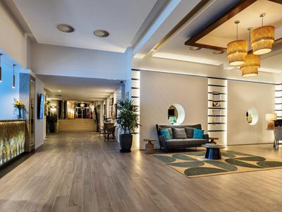 Moderner Hotel-Loungebereich mit Sesseln, Teppichen und indirekter Beleuchtung