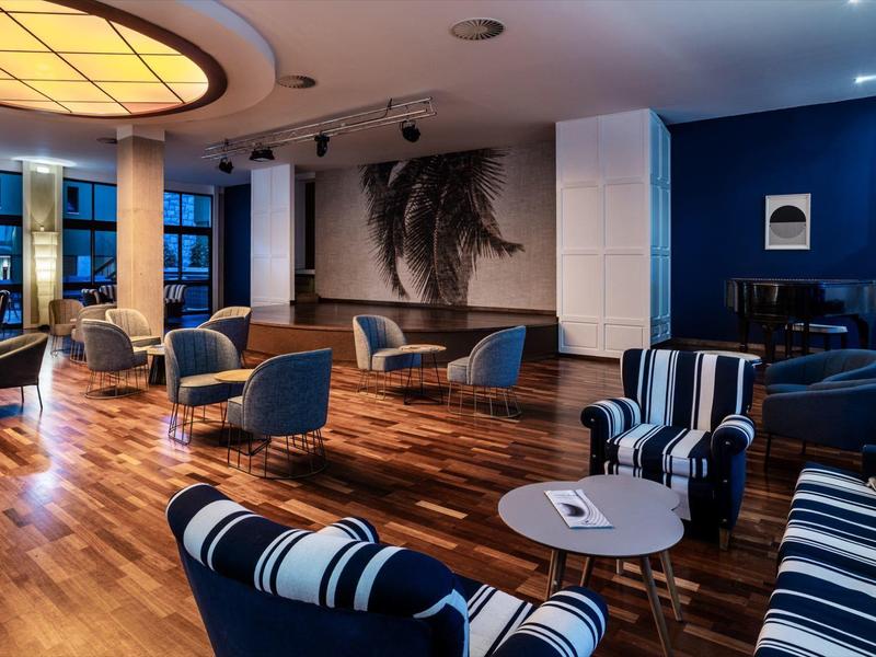 Modern ingerichte lounge met houten vloer en stoelen in maritieme stijl.