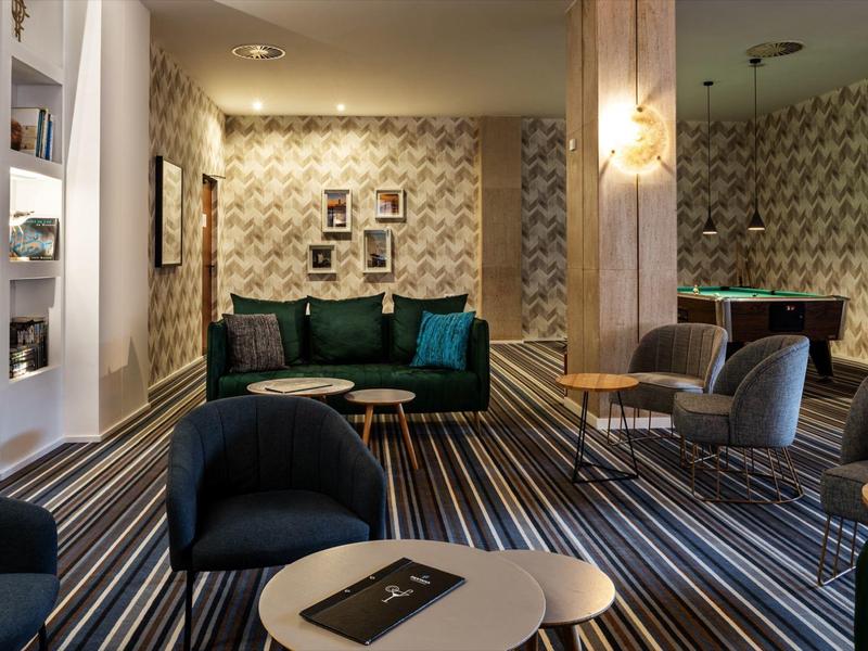 Moderne hotel lounge met gestreept tapijt, zithoeken en stijlvolle verlichting