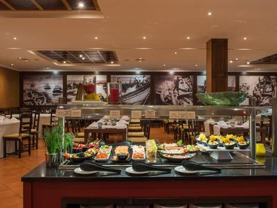 Buffet mit frischem Obst und Speisen in einem hellen, modern eingerichteten Restaurant.