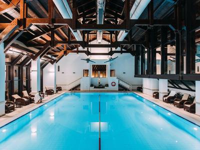 Innenraum mit beheiztem Hotelpool und Liegestühlen in modern rustikalem Stil.