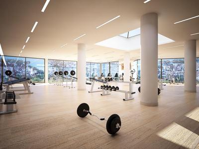 Gimnasio luminoso con equipo moderno y grandes ventanas con vistas a las montañas.