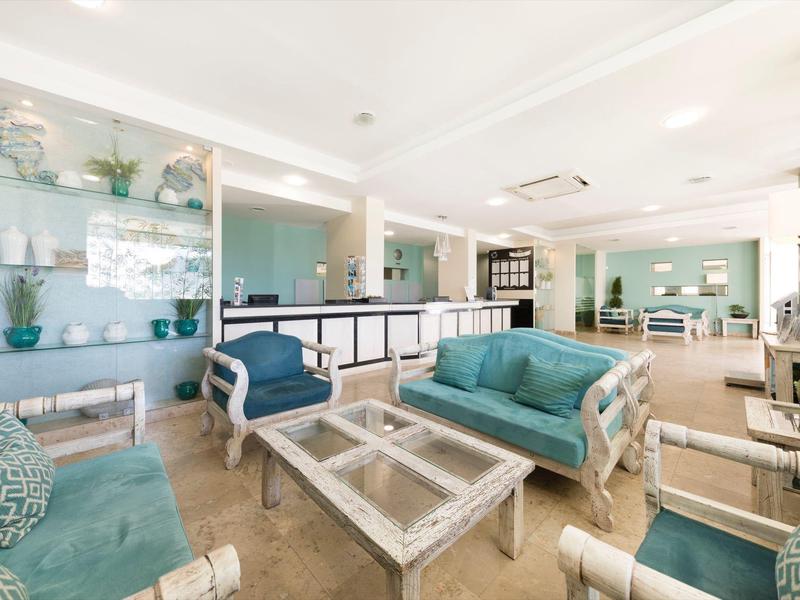 Helle, moderne Hotellobby mit blauen Sofas und Glastischen in gemütlicher Atmosphäre.