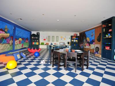 Bunter Spielraum mit blau-weiß kariertem Boden, bunten Bällen und kindgerechten Möbeln.