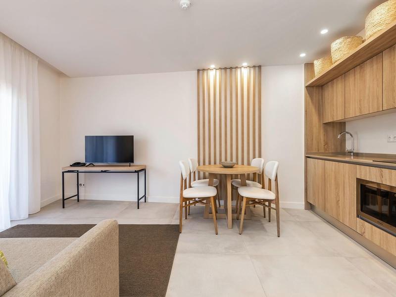 Nowoczesny salon z jadalnią, jasne meble i drewniane akcenty.