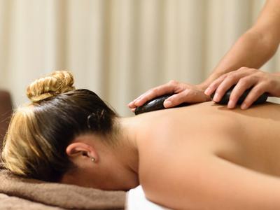 Persoon krijgt een rugmassage met handen die druk uitoefenen op de schouders.