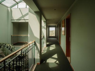 Flur in einem Hotel mit natürlichem Licht und Blick auf Pflanzen im Innenhof.