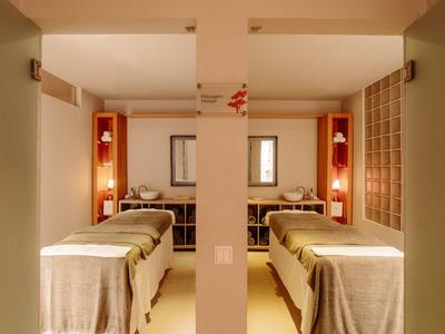 Hell beleuchteter Spa-Raum mit zwei Massageliegen und ruhiger Atmosphäre.