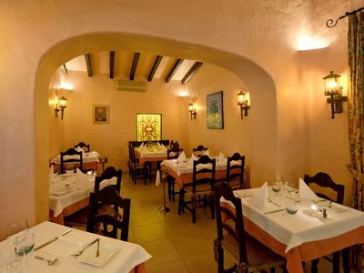 Piccola sala da pranzo accogliente con tavoli apparecchiati e decorazioni murali.