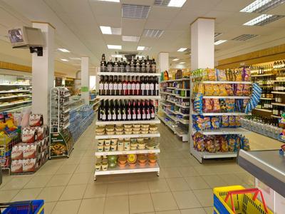 Vista all'interno di un supermercato con scaffali pieni di cibo e bevande.