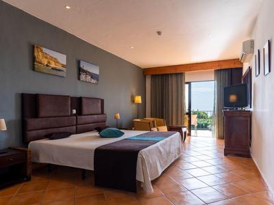 Brightly furnished hotel room with two single beds and balcony view