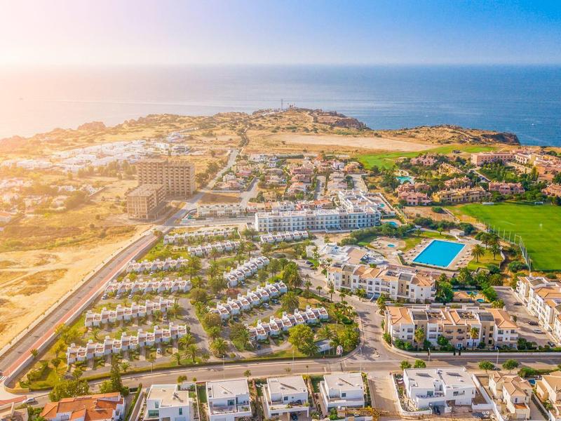 Zdjęcie z lotu ptaka nad nadmorskim kurortem z basenem o zachodzie słońca.