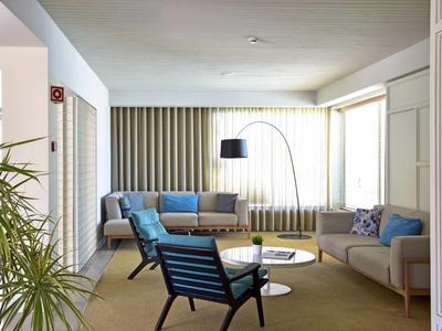 Soggiorno moderno con divani, poltrone e grandi finestre