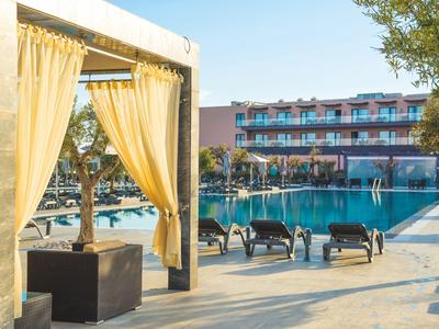 Piscina dell'hotel con lettini e tende in una giornata di sole