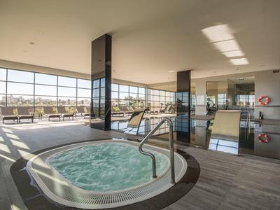 Moderner Whirlpool in hellem, geräumigem Raum mit großen Fenstern und Panoramablick.