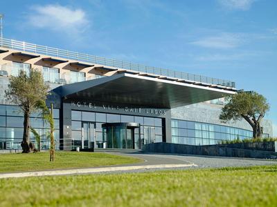 Ein ruhiger Wellnessraum mit zwei Massageliegen, rot-weiß dekoriert und gedämpftem Licht.