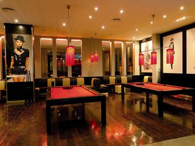 Sala da biliardo moderna con illuminazione elegante e arte murale in un hotel