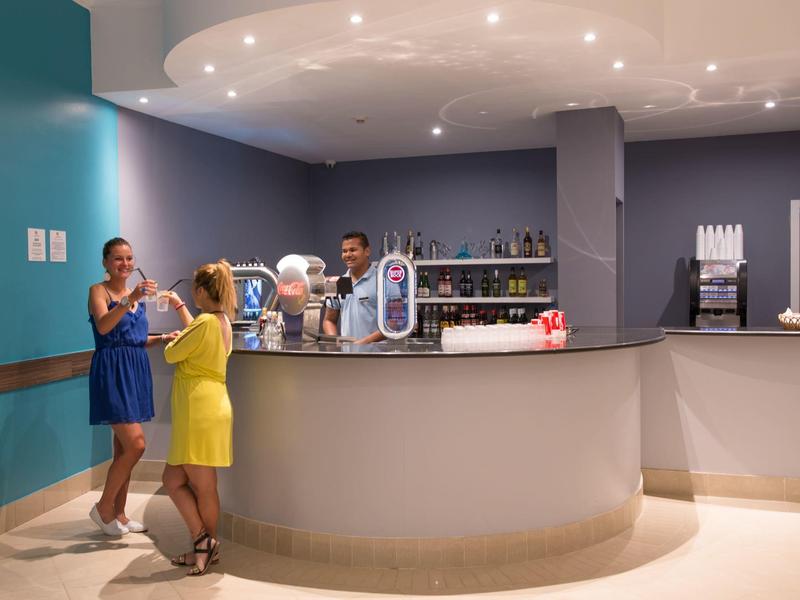 Rezeption in einem modernen Hotel mit zwei Frauen und einem Mitarbeiter hinter dem Tresen.