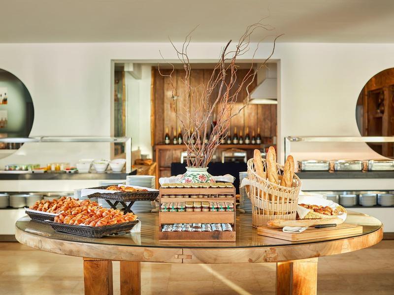Buffet mit verschiedenen Brotsorten und Gebäck, Holztablett, helle moderne Bäckerei.