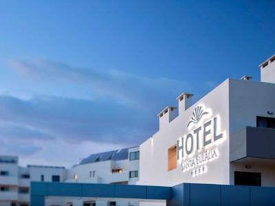 Modernes Hotelgebäude mit klarem Himmel im Hintergrund bei Dämmerung.