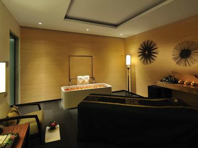 Gemütlicher Raum mit Holzwänden, dunklem Sofa, Schreibtisch und warmem, weichem Licht.